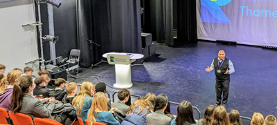 member if staff speaking to a group of students from a school in the the auditorium
