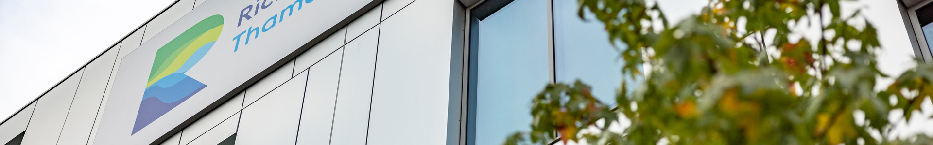 college building with logo and tree