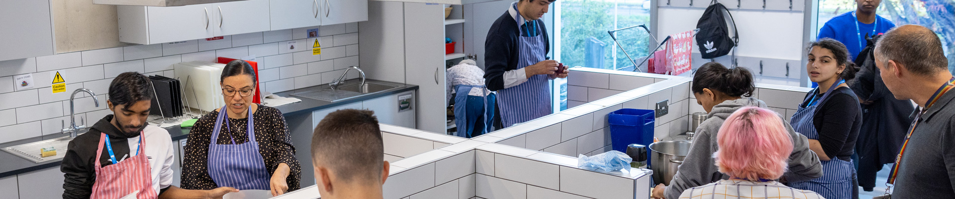 lots of students in a cookery lesson in the kitchen