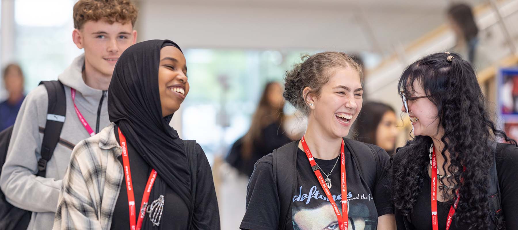 Richmond upon Thames students laughing together. They are all wearing black and grey with red lanyards. 