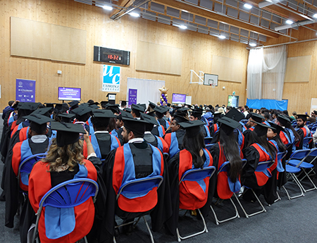 All the HE graduation students sitting in the Uxbridge College sports hall waiting for the ceremony to begin. 