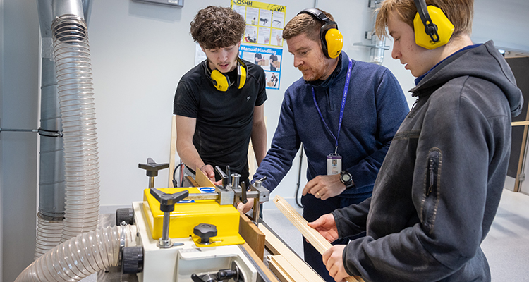 Richmond students being shown how to use one of the wood table saws.