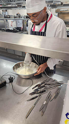 Male Catering student making cheese based recipe at cheese workshop