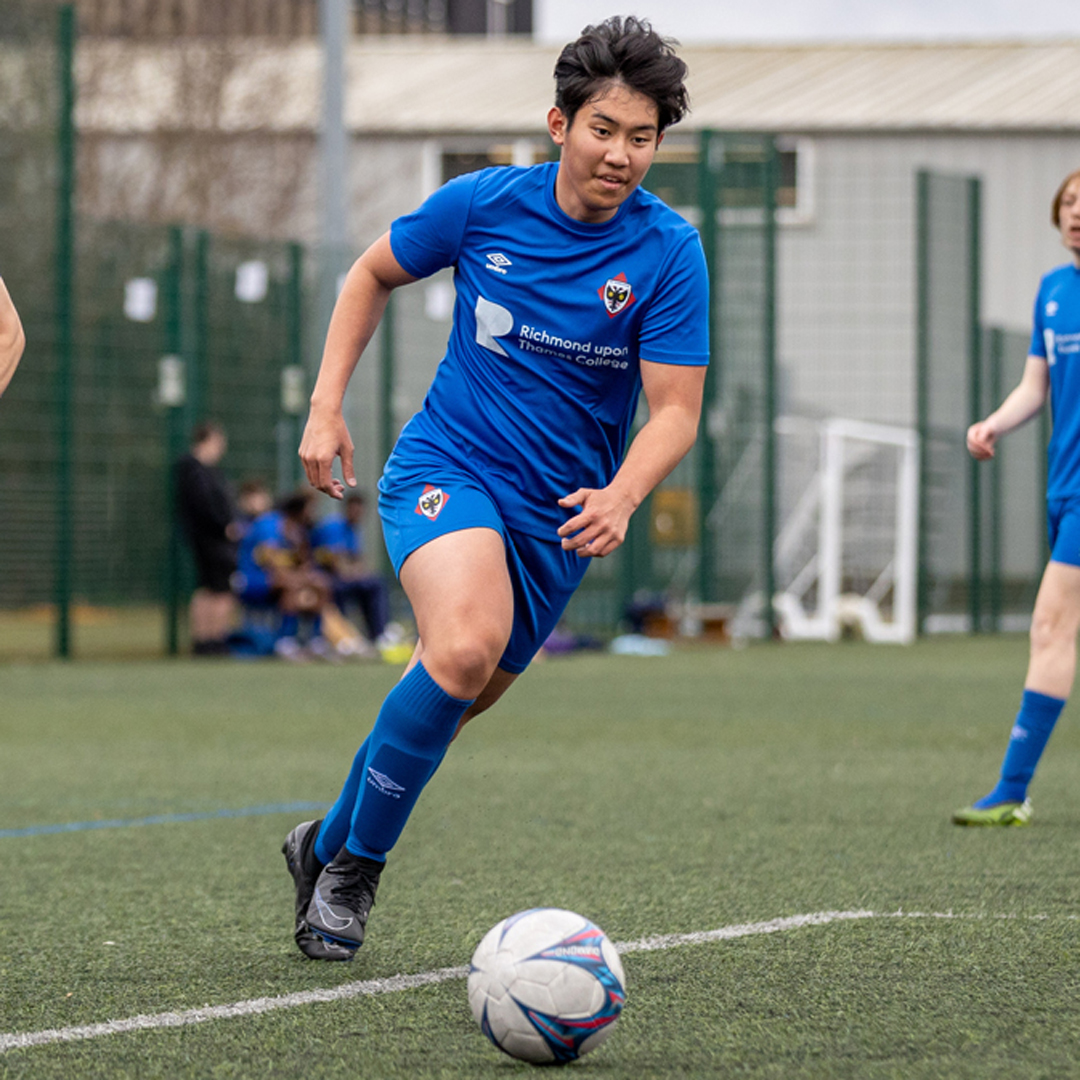 FAC Wimbledon football student running with the ball on the sports pitch