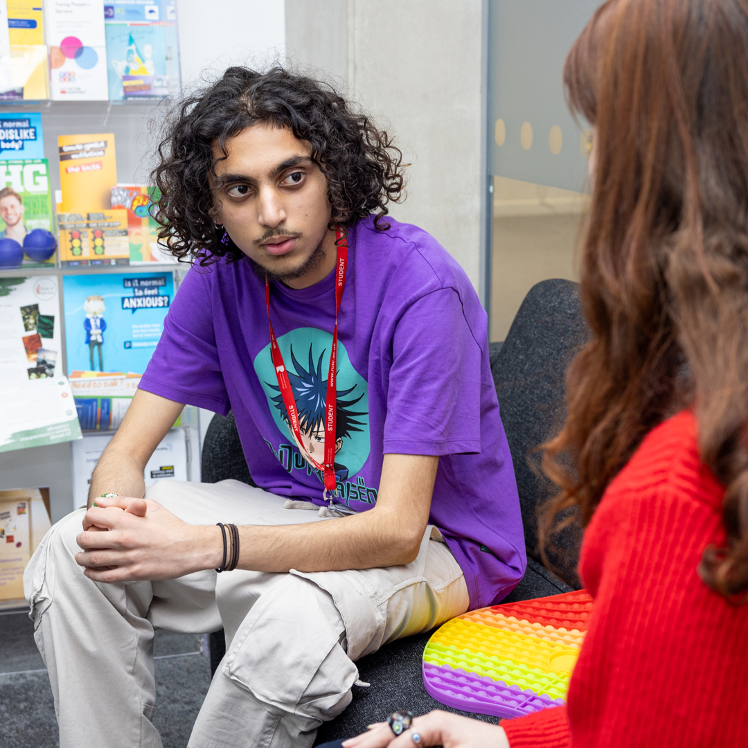 male student talking to member of student services team